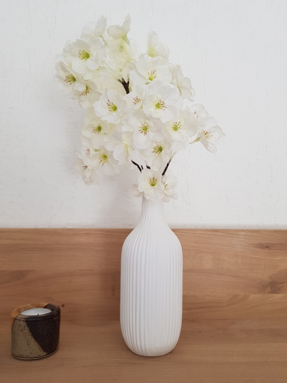 weiße Vase mit gerillter Oberfläche